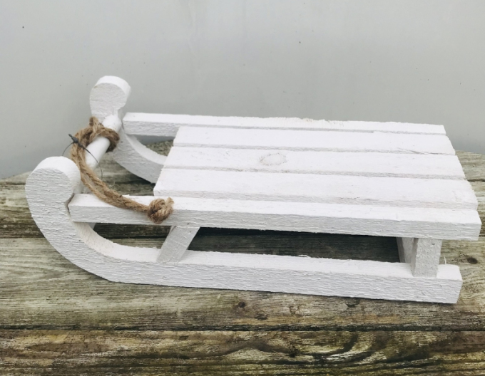 Dekorativer weißer Holzschlitten