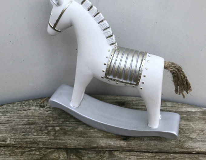 Dekoratives Schaukelpferd mit goldenem Sattel